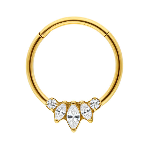 Anillo clicker de titanio dorado con cinco circonitas claras sobre fondo blanco