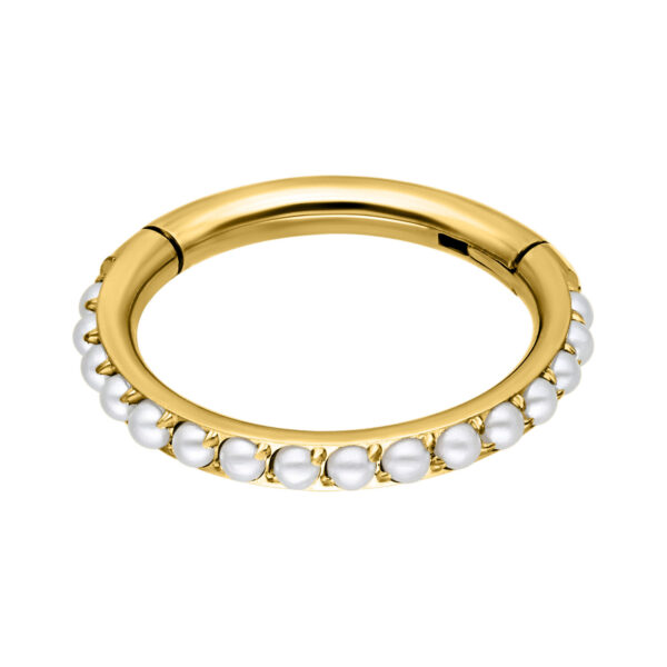 Anillo de piercing de metal dorado con perlas blancas sobre fondo blanco