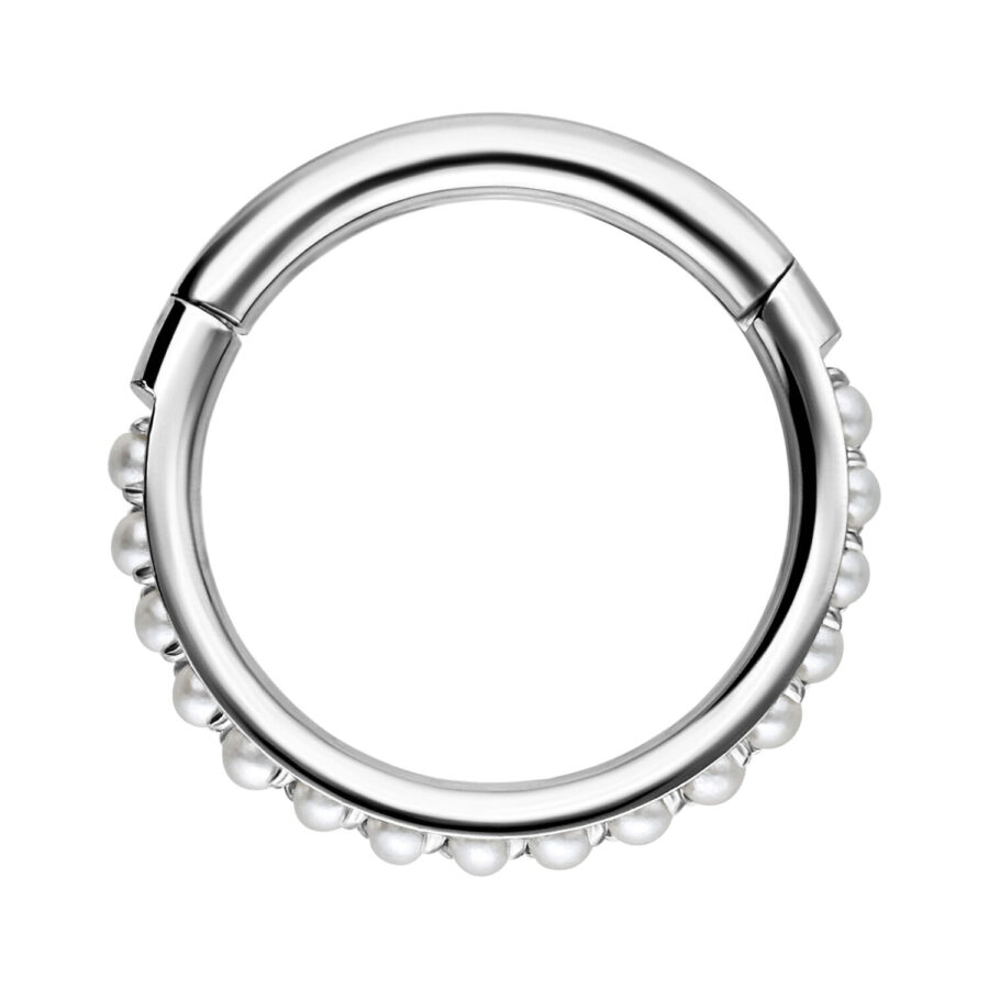 Anillo de piercing plateado con decoración de perlas sobre fondo blanco