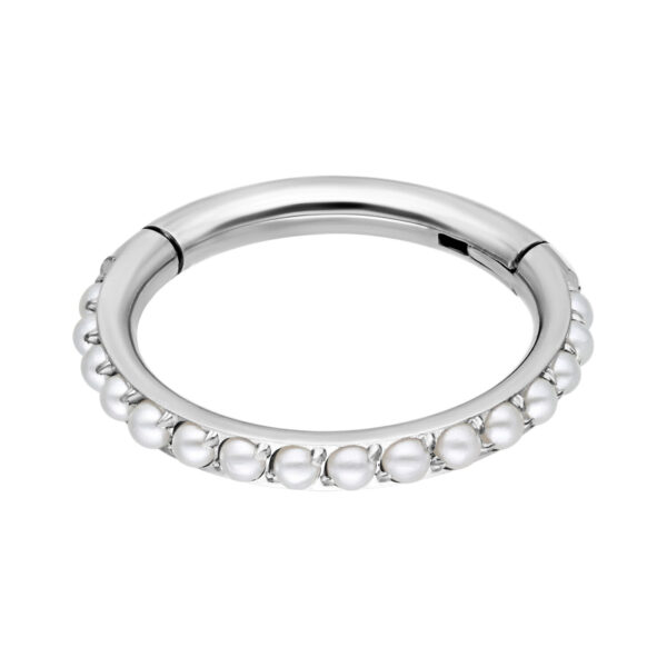 Anillo de piercing plateado con perlas blancas sobre fondo blanco
