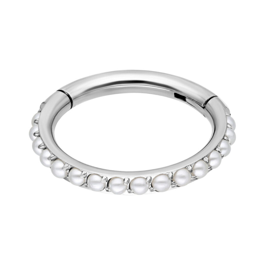Anillo de piercing plateado con perlas blancas sobre fondo blanco