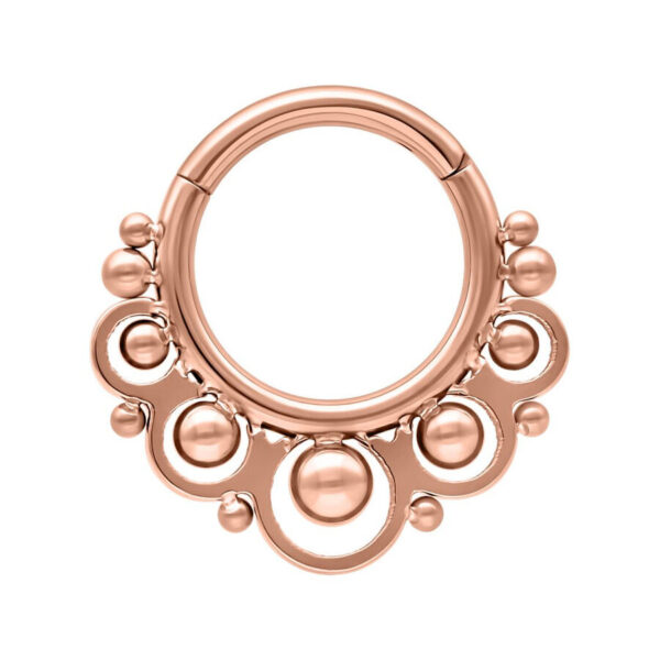 Piercing roségold en forma de anillo con bolas decorativas sobre fondo blanco