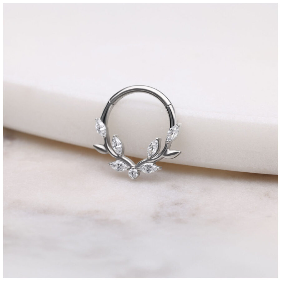 Clicker de septum plateado con hojas de cristal sobre fondo blanco