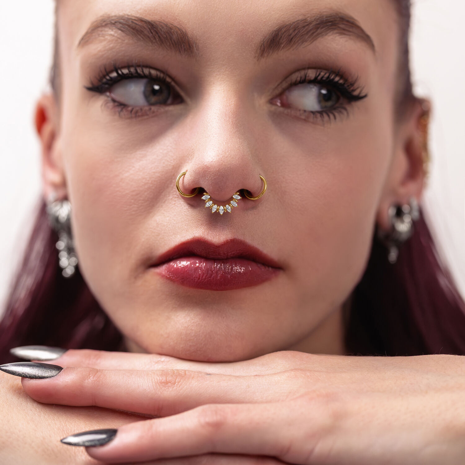 Mujer lleva un Marquise Sunburst Septum Clicker dorado con piedras brillantes