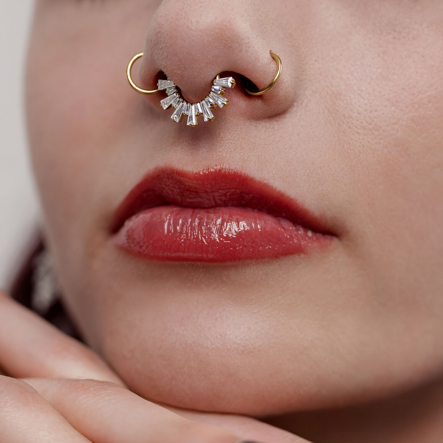 Clicker de septum de cristal dorado Primer plano de un clicker de septum dorado con cristales en una nariz