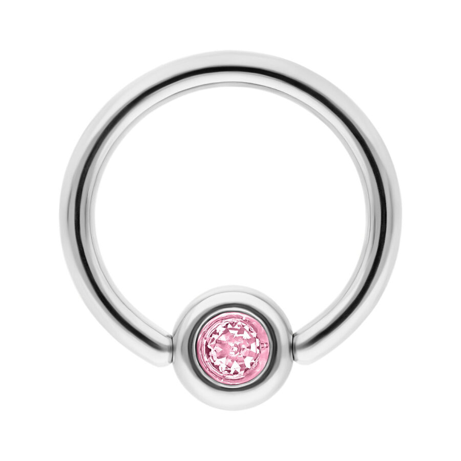 Anillo de titanio plateado con cristal rosa sobre fondo blanco
