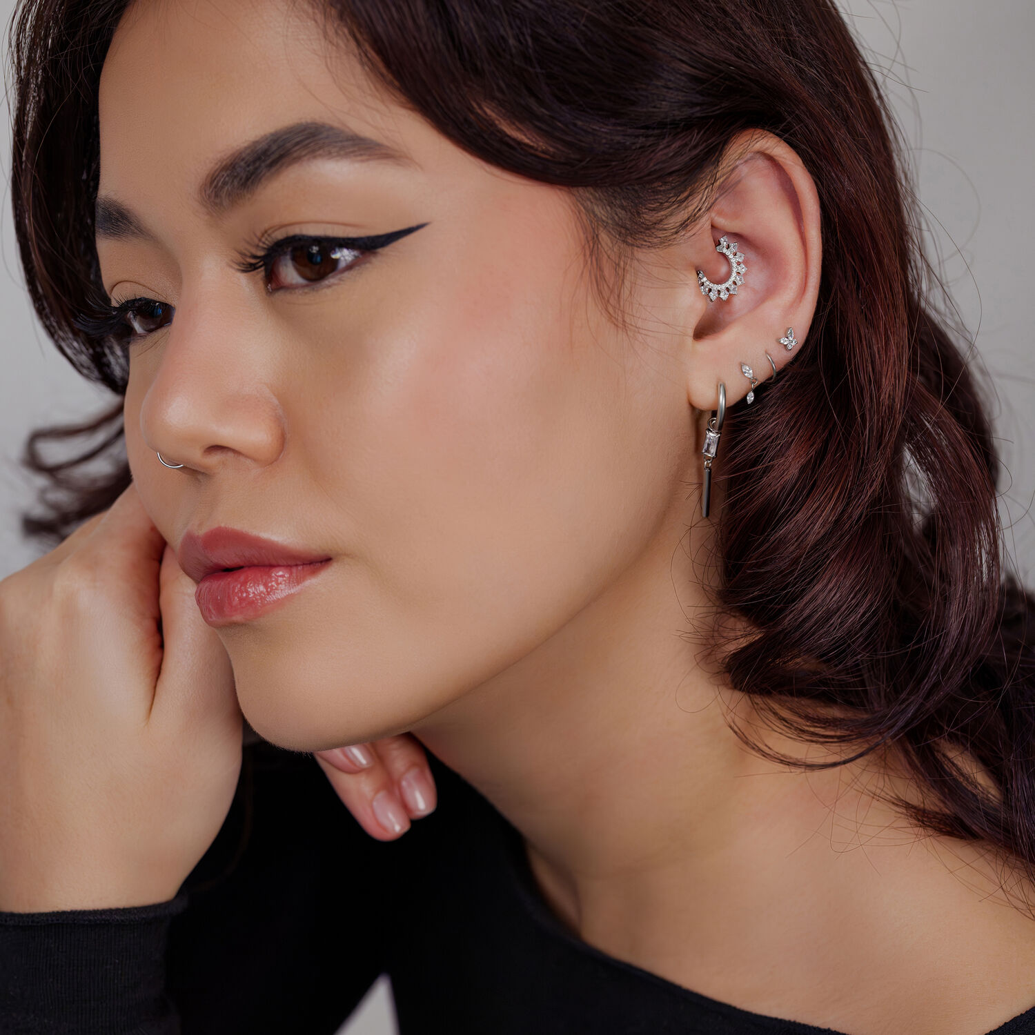 Mujer con varios pendientes y un clicker de septum plateado con cristales
