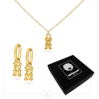 Conjunto de joyas de osito de goma dorado Collar y pendientes dorados con colgantes de osito de goma sobre fondo blanco