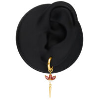Pendientes dorados con cristales rojos Pendiente dorado con cristales rojos en un modelo de oreja negra