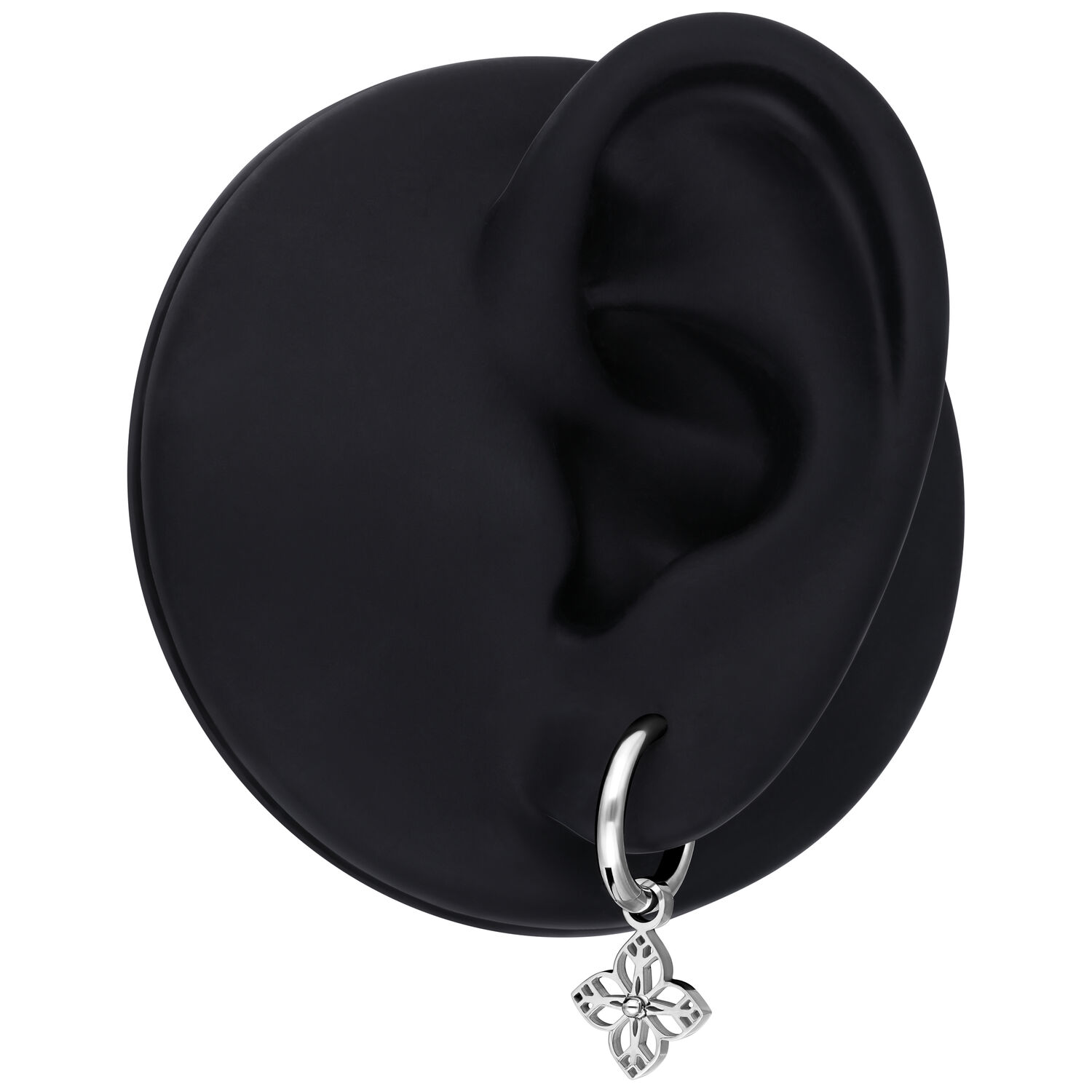 Pendiente de plata con pequeño colgante de flor, presentado en un modelo de oreja negra