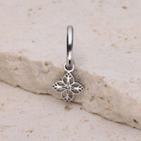 Pendiente de plata con colgante en forma de flor sobre piedra clara