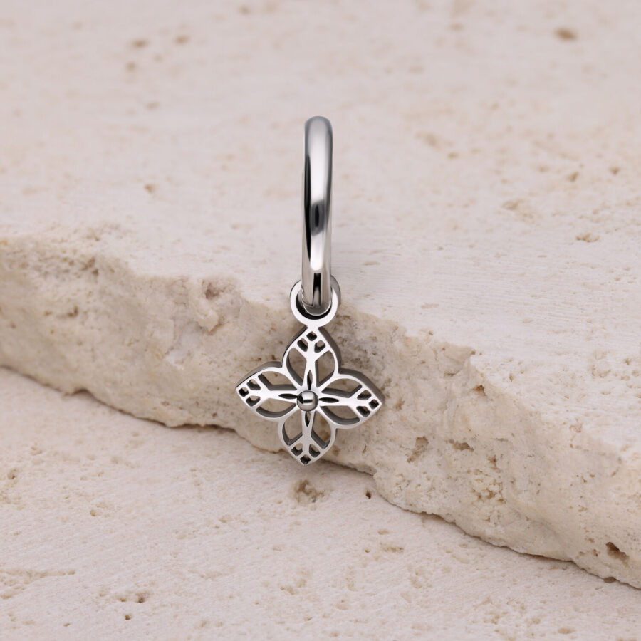 Pendiente de plata con colgante en forma de flor sobre piedra clara