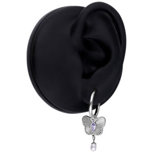 Pendiente plateado con colgante de mariposa lila y perla en un modelo de oreja negra