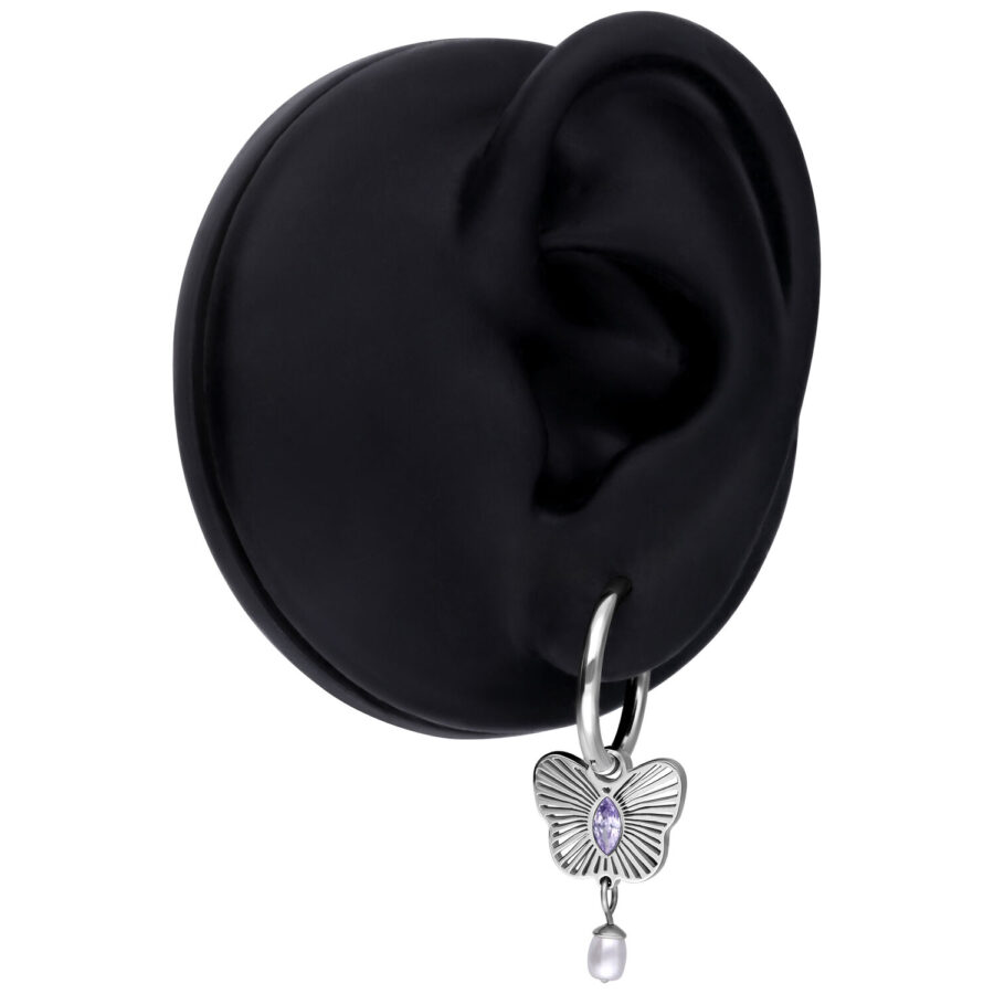Pendiente plateado con colgante de mariposa lila y perla en un modelo de oreja negra
