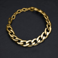 Pulsera Chunky dorada de acero quirúrgico sobre fondo negro