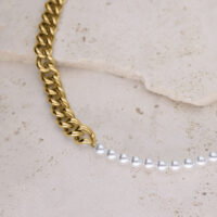 Collar dorado con grandes eslabones y perlas sintéticas blancas sobre piedra clara