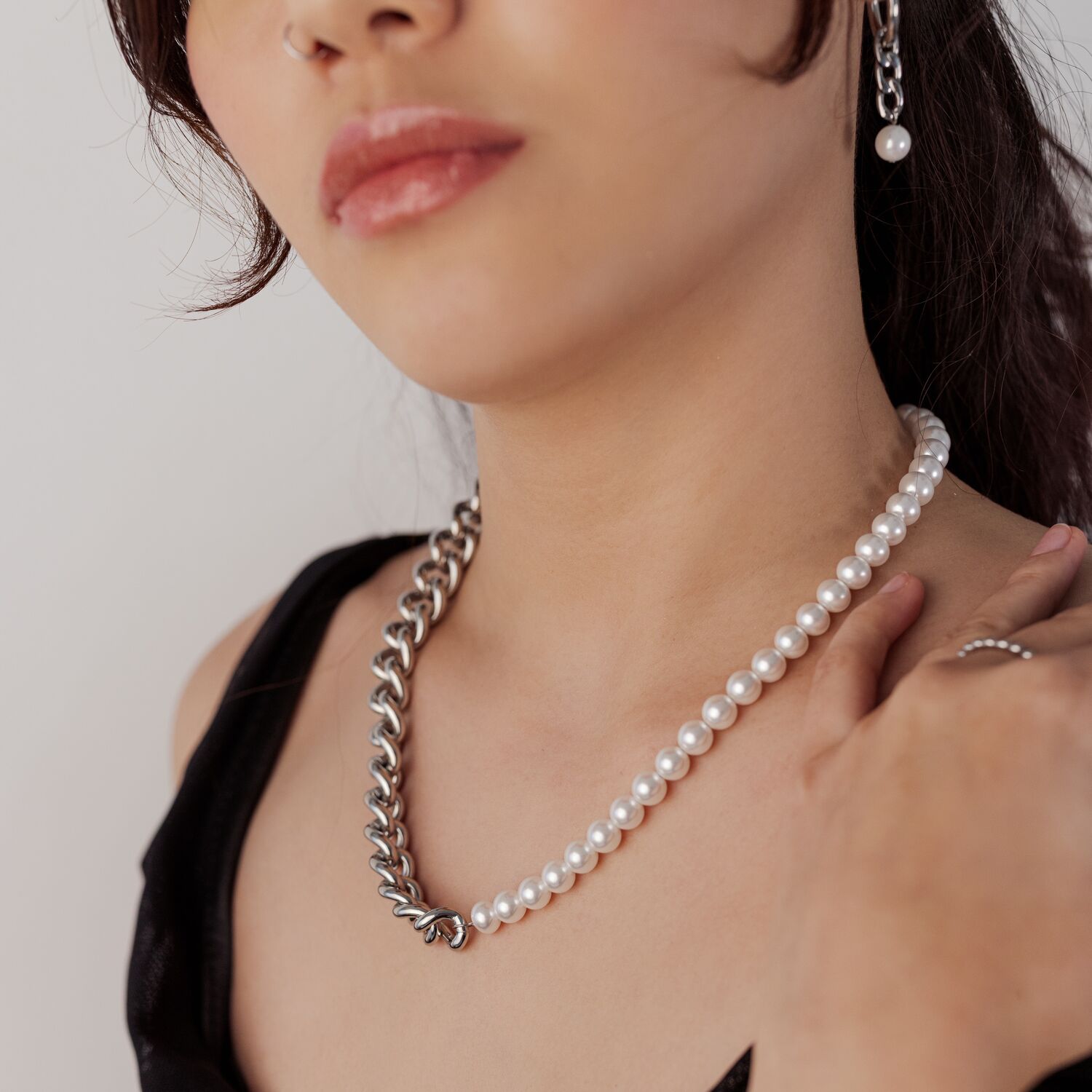 Chunky Pearl Collar con Cadena de Plata Mujer con collar de plata y perlas sobre fondo claro