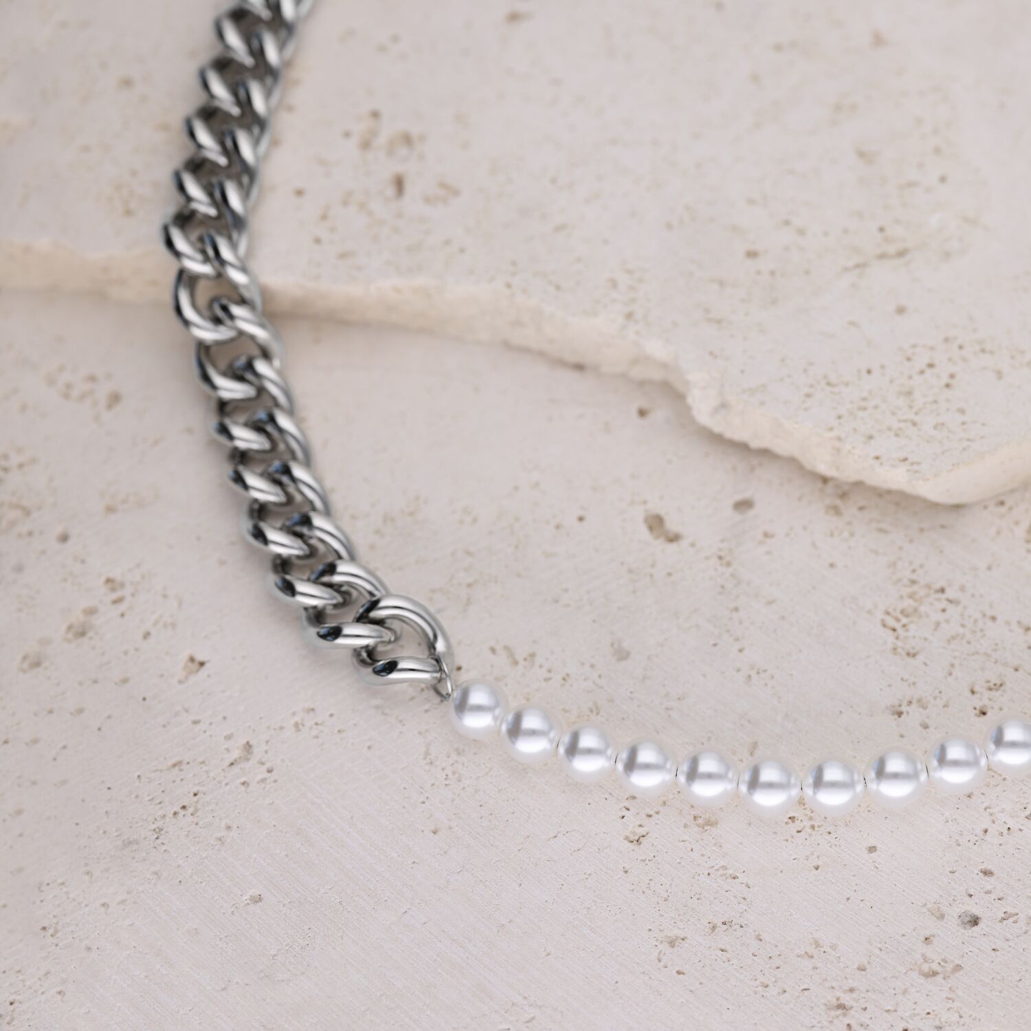 Collar Chunky Pearl en Plata Collar plateado con perlas sobre fondo de piedra clara