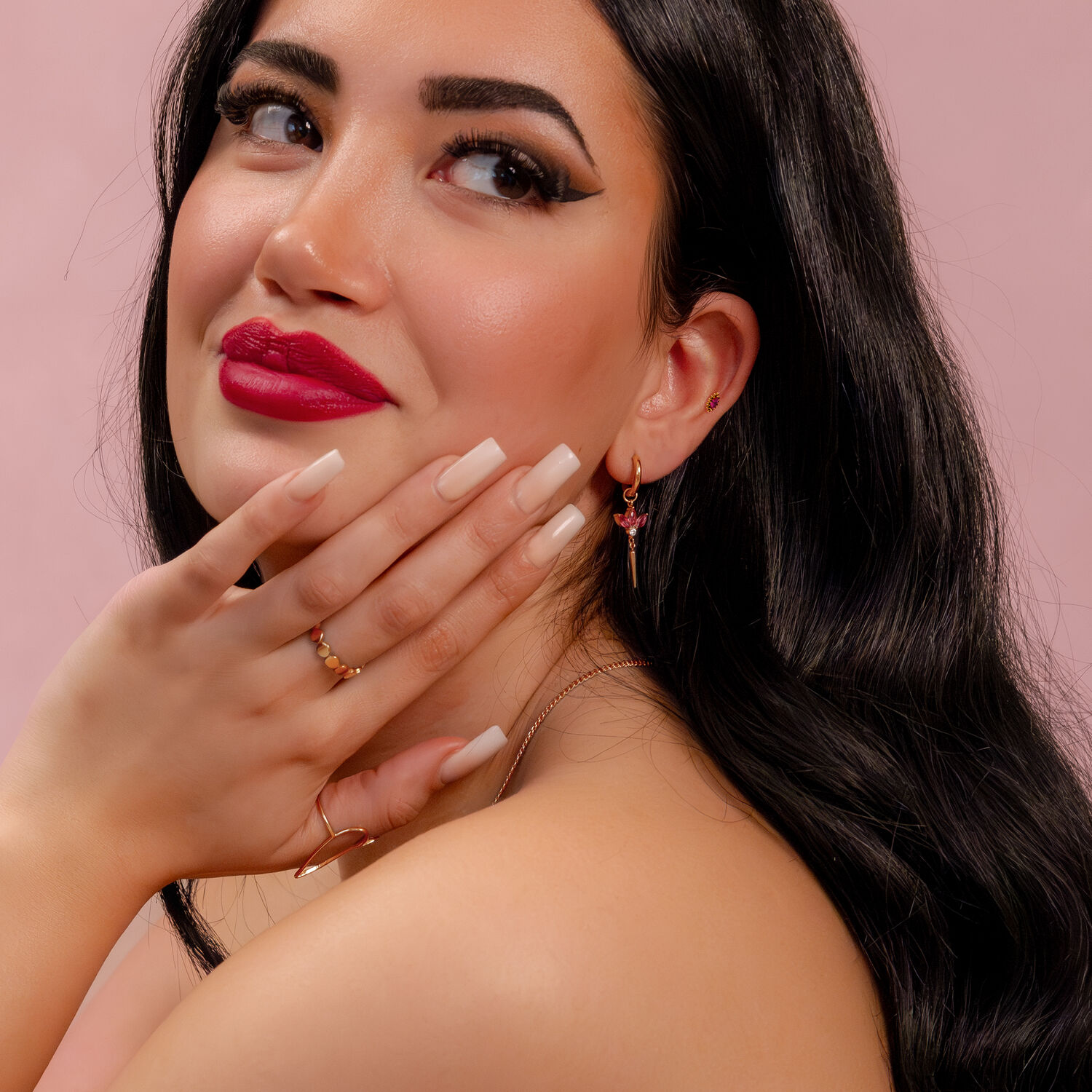 Aplique de piercing de rubí rojo Mujer con pendiente de rubí rojo, sonriendo, fondo rosa