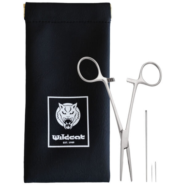 Pinza de piercing plateada y agujas junto a bolsa negra con logo de Wildcat