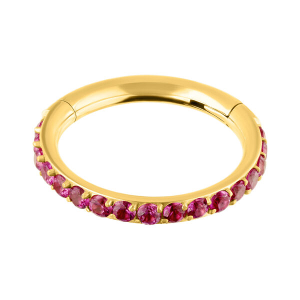 Anillo dorado con cristales rojos, sobre fondo blanco