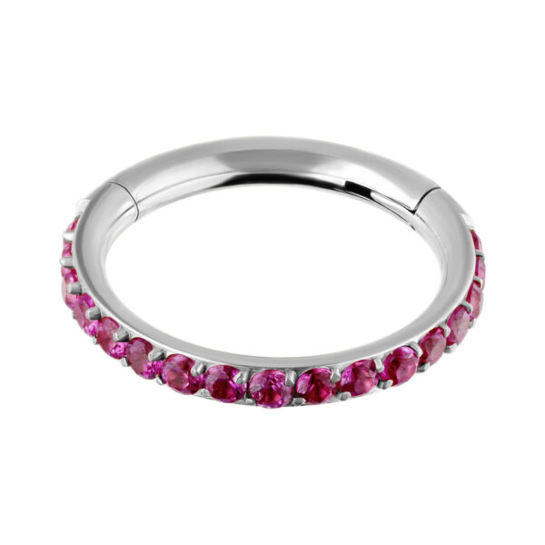 Anillo plateado con cristales rojos sobre fondo blanco