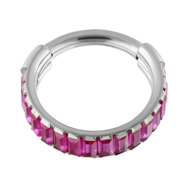 Anillo plateado con cristales baguette rojos sobre fondo blanco