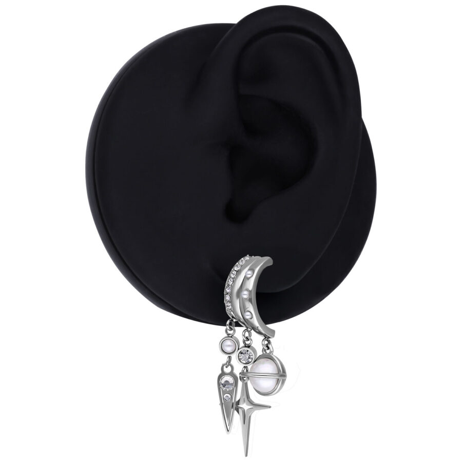 Pendiente plateado con colgante de planeta y estrella en un modelo de oreja negra