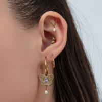 Pendientes de mariposa dorados con cristal lavanda Oreja con varios pendientes dorados, incluyendo un diseño de mariposa con cristal lavanda