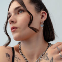 Mujer con aros de mariposa plateados, primer plano