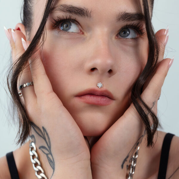 Mujer con piercing de cristal plateado en el rostro, primer plano