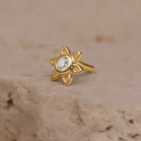 Aplique dorado de flor con cristal claro, sobre piedra