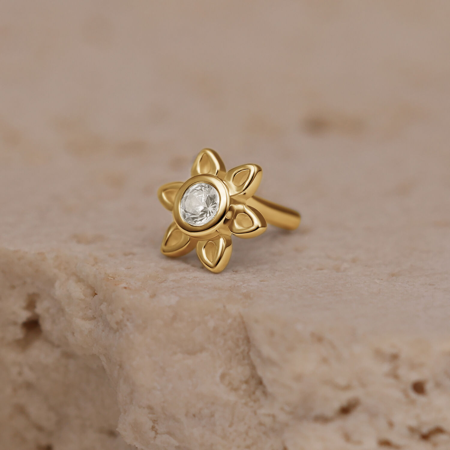 Aplique dorado de flor con cristal claro, sobre piedra
