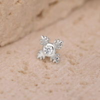 Accesorio de piercing Push Fit plateado en forma de hoja con cristal claro sobre fondo arenoso