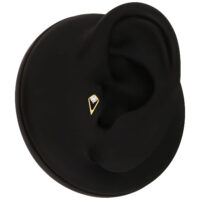 Accesorio de piercing dorado en modelo de oreja negra sobre fondo blanco