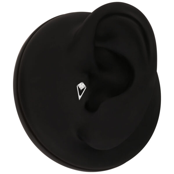Accesorio negro para piercing con cristal claro en un modelo de oreja negra