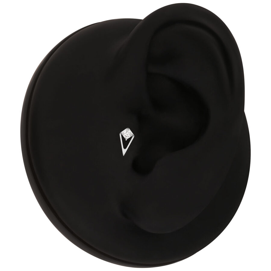 Accesorio negro para piercing con cristal claro en un modelo de oreja negra