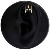 Accesorio dorado para piercing de hélice con cristales Accesorio de piercing dorado con cristales ovalados en un modelo de oreja negra