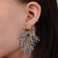 Pendientes de plata con diseño floral delicado Primer plano de una oreja con pendiente de plata en forma de flor y pequeño broche