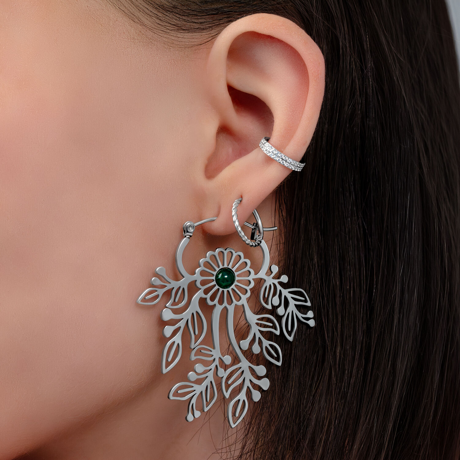 Pendientes de plata con diseño floral delicado Primer plano de una oreja con pendiente de plata en forma de flor y pequeño broche