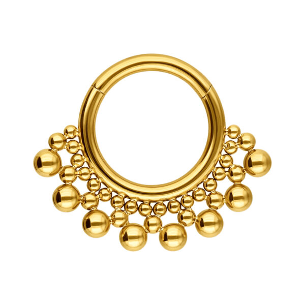 Clicker de septum dorado con adornos de bolas sobre fondo blanco