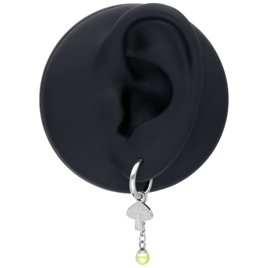 Oreja negra con pendiente plateado y colgante de champiñón sobre fondo blanco