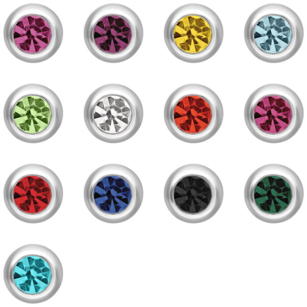 Diferentes accesorios de piercing con cristales coloridos sobre fondo blanco