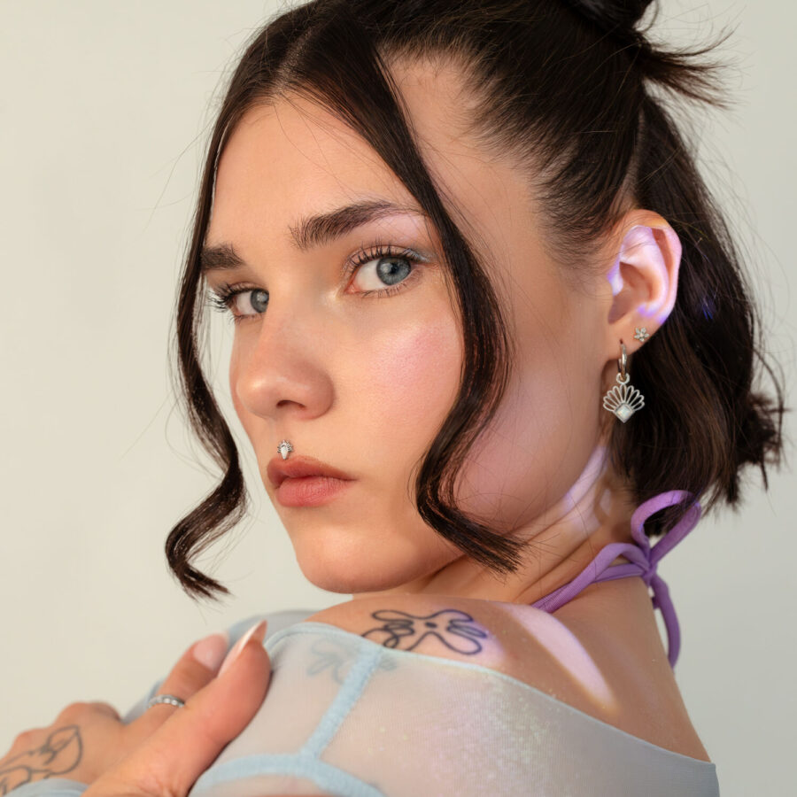 Mujer con cabello corto oscuro y aplique de rayos de sol en la oreja