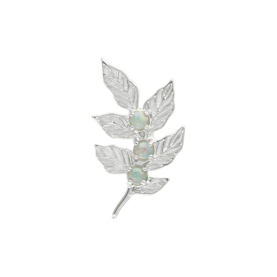 Aplique de hoja de oro blanco con tres piedras de color ópalo sobre fondo blanco