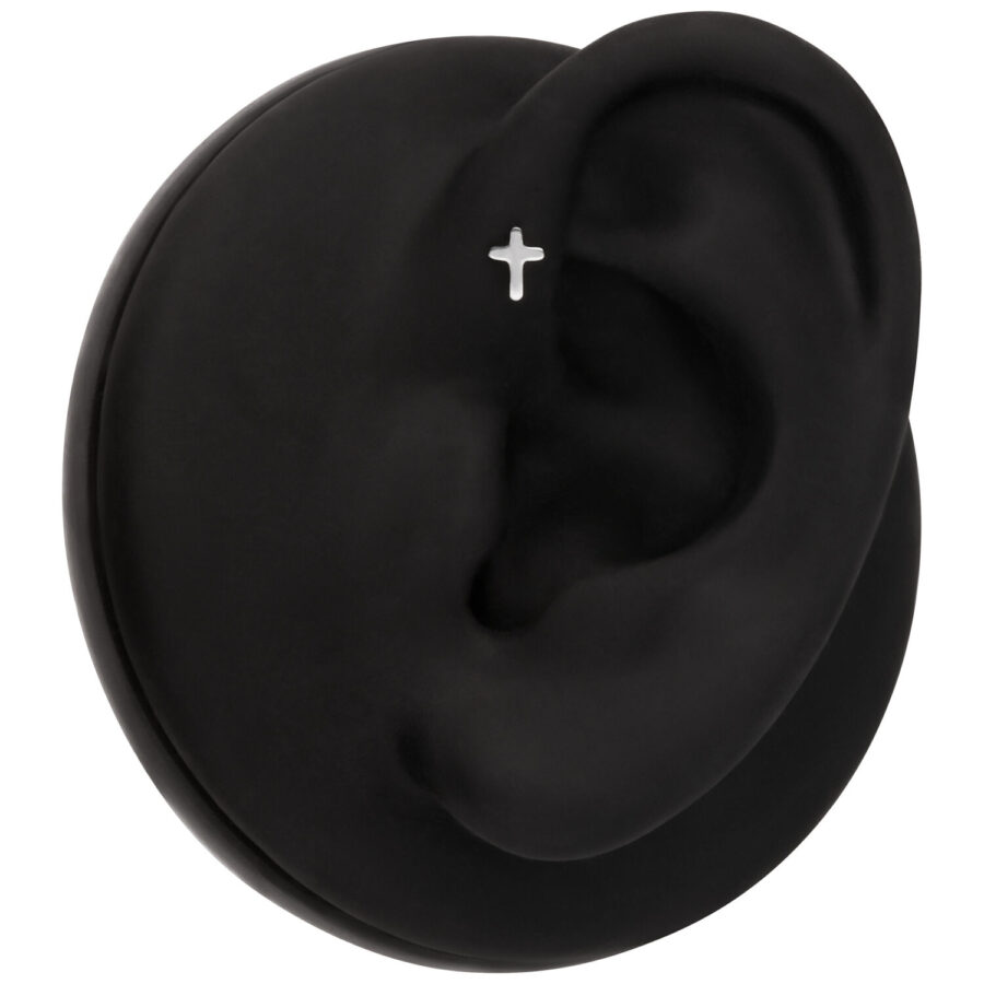 Modelo de oreja negra con piercing de cruz plateada sobre fondo negro