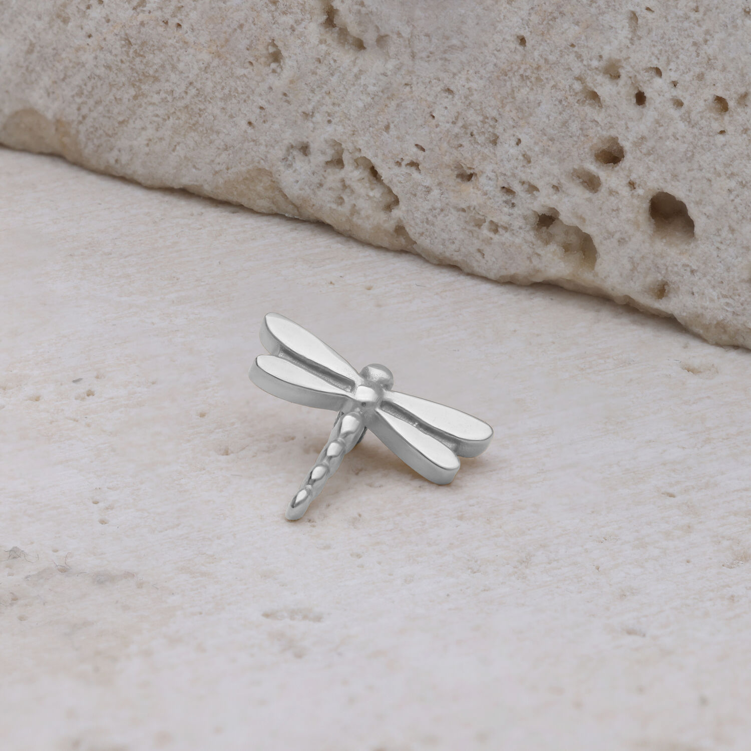 Adjunto de libélula de oro blanco de titanio Adjunto de libélula de oro blanco de titanio sobre piedra clara