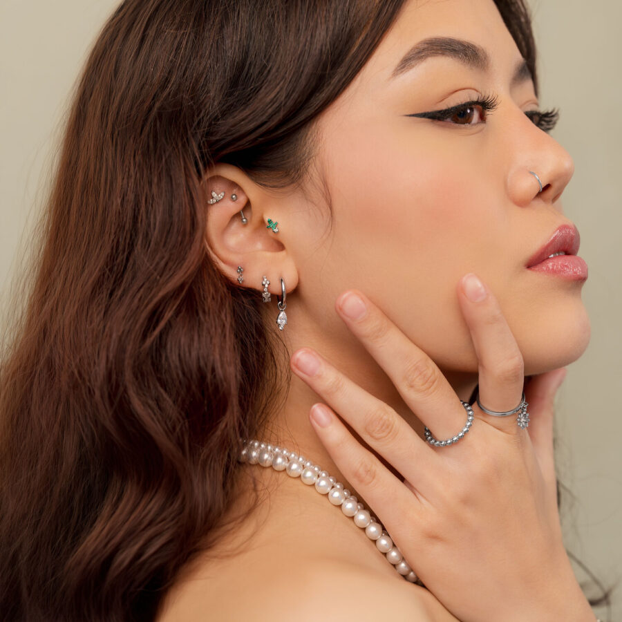 Mujer con varios piercings de plata, incluido Cactus Push Fit, fotografiada de lado