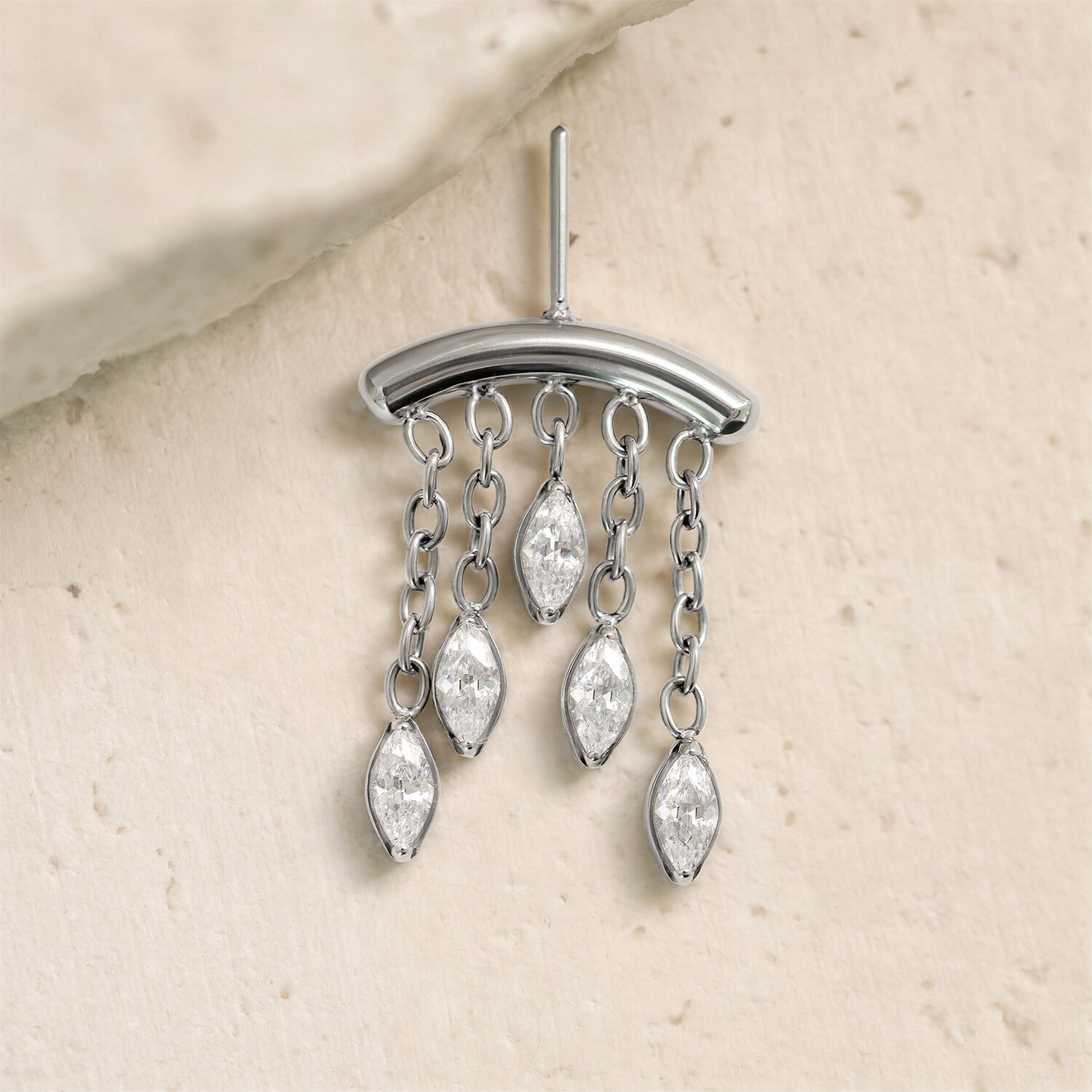 Accesorio de hélice plateado con gotas de cristal Accesorio plateado con cinco gotas de cristal claro en cadenas sobre fondo claro