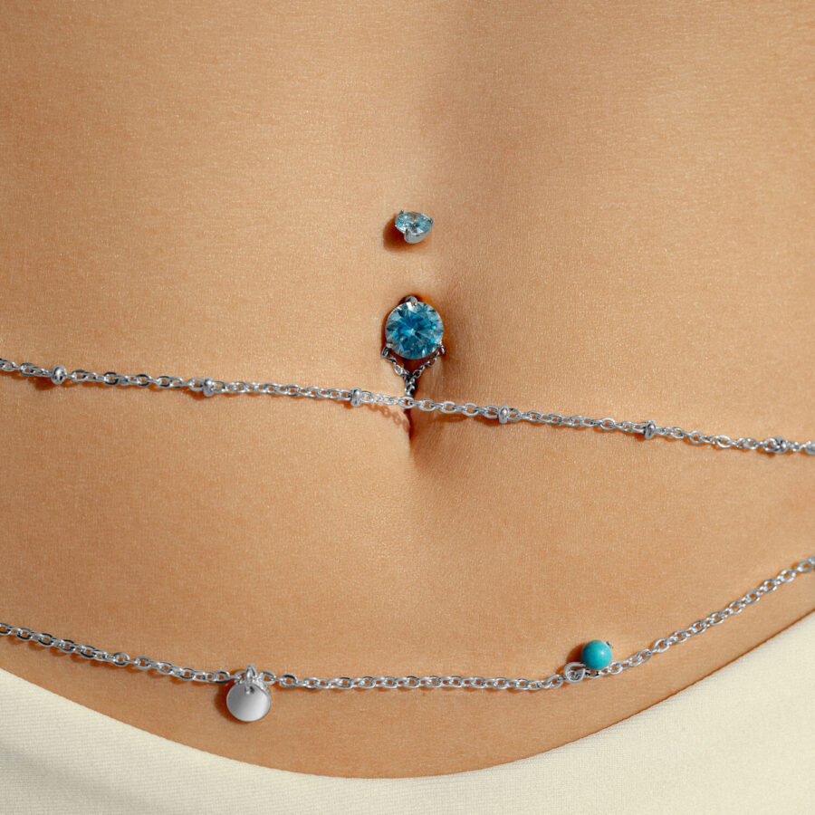 Ombligo con cristal turquesa y cadena sobre piel